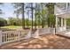 A spacious home's wooden deck features white railings and views of the luscious green lawn and towering trees at 101 Preston Arbor Ln, Cary, NC 27513
