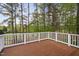 An exterior wooden deck with white railing offers beautiful views of the surrounding tree-lined landscape at 101 Preston Arbor Ln, Cary, NC 27513