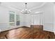 A dining room with hardwood floors, large windows, and modern lighting at 101 Preston Arbor Ln, Cary, NC 27513