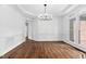 A formal dining room with a modern chandelier, large windows, and hardwood floors at 101 Preston Arbor Ln, Cary, NC 27513