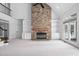 Spacious living room with a stone fireplace, built-in shelving, and an open staircase at 101 Preston Arbor Ln, Cary, NC 27513