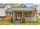 Charming brick home featuring a cozy covered porch and well-maintained landscaping at 101 W Thorndale Dr, Oxford, NC 27565