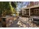 An inviting backyard with a stone patio, outdoor kitchen, and covered seating area with an entertainment center at 102 Kamprath Pl, Cary, NC 27519