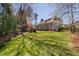 A large, well-maintained backyard with a green lawn, lush landscaping, and the home's rear exterior at 102 Kamprath Pl, Cary, NC 27519