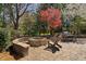 A charming backyard retreat with a fire pit, Adirondack chairs, an outdoor grill, and dining table surrounded by lush landscaping at 102 Kamprath Pl, Cary, NC 27519