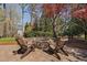 A cozy backyard with a stone fire pit surrounded by Adirondack chairs and landscaped gardens, perfect for entertaining at 102 Kamprath Pl, Cary, NC 27519