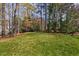 Expansive backyard featuring a well-manicured lawn and mature trees, offering privacy and a serene outdoor space at 102 Kamprath Pl, Cary, NC 27519