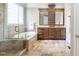 Spacious bathroom featuring double sinks, soaking tub, walk-in shower, and neutral tiling at 102 Kamprath Pl, Cary, NC 27519