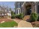 Close-up of the entrance with a stone archway, landscaped garden, and stone steps at 102 Kamprath Pl, Cary, NC 27519