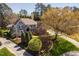 Aerial shot showcases this home's manicured landscaping, mature trees, a circular driveway, and stone and siding exterior at 102 Kamprath Pl, Cary, NC 27519