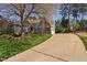 A sprawling home with a three-car garage, lush lawn, mature trees, and a long driveway, showcasing curb appeal at 102 Kamprath Pl, Cary, NC 27519