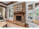 Stone fireplace with wood mantel, and windows overlooking the backyard at 102 Kamprath Pl, Cary, NC 27519
