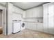 Spacious laundry room with white cabinetry, washer, dryer, sink, and ample countertop space; a practical and functional area at 102 Kamprath Pl, Cary, NC 27519