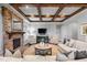 Living room with stone fireplace, wood beam ceiling and hardwood floors at 102 Kamprath Pl, Cary, NC 27519