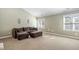 Living room area with carpet flooring, seating, windows, and neutral paint that gets plenty of natural light at 102 Kamprath Pl, Cary, NC 27519