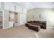 Spacious living room featuring carpet flooring, seating for entertaining guests, and built-in storage at 102 Kamprath Pl, Cary, NC 27519