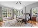 Bright main bedroom featuring four poster bed, hardwood flooring, and large windows at 102 Kamprath Pl, Cary, NC 27519