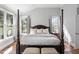 Well-lit main bedroom showcasing four poster bed, large windows, and hardwood flooring at 102 Kamprath Pl, Cary, NC 27519
