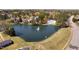 Aerial view of a pond featuring a fountain, pool, and clubhouse nestled within a neighborhood at 102 Kamprath Pl, Cary, NC 27519