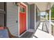 Inviting front porch featuring a bright red door, stylish lighting, and comfortable wicker furniture at 1020 Retriever Ln, Raleigh, NC 27603
