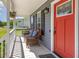 Inviting front porch featuring a bright red door, stylish lighting, and comfortable wicker furniture at 1020 Retriever Ln, Raleigh, NC 27603
