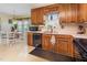 Traditional kitchen with wood cabinets, black appliances, and a breakfast nook at 1020 Retriever Ln, Raleigh, NC 27603