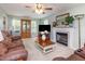 Cozy living room with fireplace, leather sofa, ceiling fan, and natural light at 1020 Retriever Ln, Raleigh, NC 27603