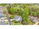 Lovely aerial view of landscaped yard, mature trees, and desirable golf course community neighborhood at 104 Vervain Way, Holly Springs, NC 27540