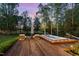 Backyard showcasing a wooden deck with a hot tub, lounge chairs and outdoor lighting at 104 Vervain Way, Holly Springs, NC 27540