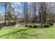 Well-manicured backyard featuring lush green grass, trimmed hedges, and decorative stone pathway at 104 Vervain Way, Holly Springs, NC 27540