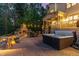 Backyard with stone fireplace, outdoor dining, and spa near covered porch at 104 Vervain Way, Holly Springs, NC 27540