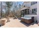 Spacious backyard with stone fireplace, dining area, hot tub, and patio at 104 Vervain Way, Holly Springs, NC 27540