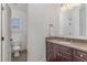Bathroom featuring a dark wood vanity with a granite countertop, and a toilet visible through the doorway at 104 Vervain Way, Holly Springs, NC 27540