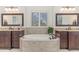 Luxurious bathroom features a soaking tub, double vanities, granite countertops, and updated fixtures at 104 Vervain Way, Holly Springs, NC 27540