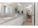 Well-lit bathroom featuring double sinks, granite countertops, and white cabinetry at 104 Vervain Way, Holly Springs, NC 27540