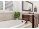 Spa-like bathroom featuring a large soaking tub and a granite countertop vanity at 104 Vervain Way, Holly Springs, NC 27540
