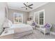 Bright bedroom featuring a comfortable bed, sitting area, and large windows with shutter blinds at 104 Vervain Way, Holly Springs, NC 27540