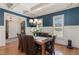 Elegant dining room featuring wainscoting, hardwood floors, and a stylish chandelier at 104 Vervain Way, Holly Springs, NC 27540
