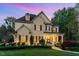 Charming stone-clad home with well-manicured lawn, covered entry, and seasonal wreaths hanging on the doors at 104 Vervain Way, Holly Springs, NC 27540