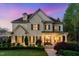 Charming stone home with a manicured lawn and inviting entrance at twilight at 104 Vervain Way, Holly Springs, NC 27540