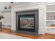 Close-up view of the fireplace featuring a stone surround and custom mantel at 104 Vervain Way, Holly Springs, NC 27540