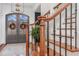 Elegant foyer features a wooden staircase and view of the front doors with wreaths at 104 Vervain Way, Holly Springs, NC 27540