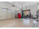Spacious garage featuring ample storage, gym equipment, and a window with a view to a serene backyard at 104 Vervain Way, Holly Springs, NC 27540