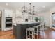 Spacious kitchen with a large island, breakfast bar, and modern pendant lighting at 104 Vervain Way, Holly Springs, NC 27540