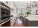 Well-lit kitchen featuring stainless steel appliances, white cabinets, and hardwood floors at 104 Vervain Way, Holly Springs, NC 27540