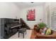 Living room with a black piano, lounge chair, and a large painting at 104 Vervain Way, Holly Springs, NC 27540