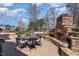 Outdoor dining area with stone fireplace and sitting area overlooking the pool at 104 Vervain Way, Holly Springs, NC 27540