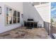 Stone patio with outdoor kitchen with stainless steel grill and white plank siding at 104 Vervain Way, Holly Springs, NC 27540