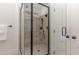 Elegant shower with a glass door and neutral-toned tiling, offering a modern and luxurious feel at 104 Vervain Way, Holly Springs, NC 27540