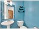 Stylish half-bathroom features bright blue walls and a pedestal sink at 105 Hobson Pl, Louisburg, NC 27549